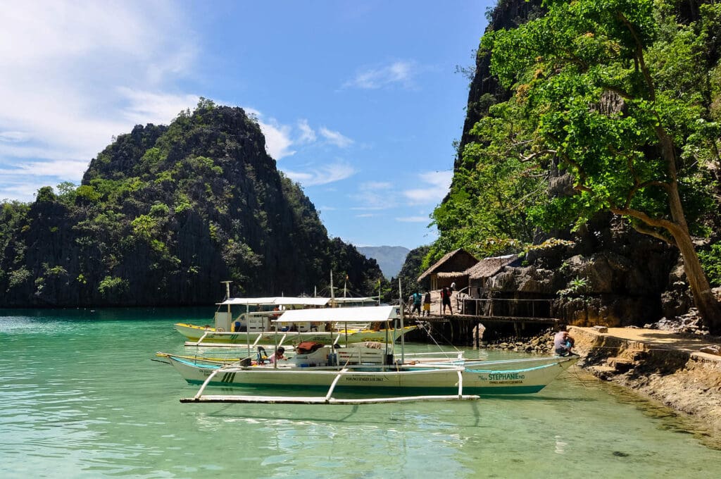 Traditional wooden filipino boats in a blue lagoon at tropical i