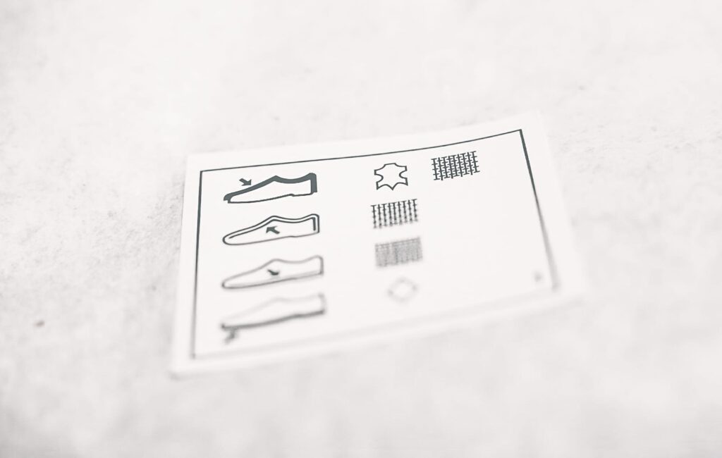 Wat betekent die ‘nutteloze’ sticker aan de onderkant van je schoen nou?