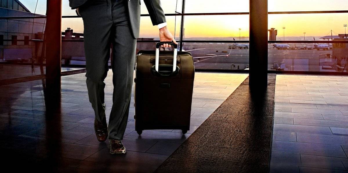 Business man with suitcase in hall of airport