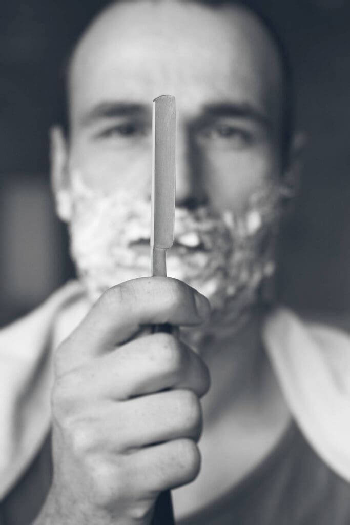 Young Man Holding Straight Razor. Black And White