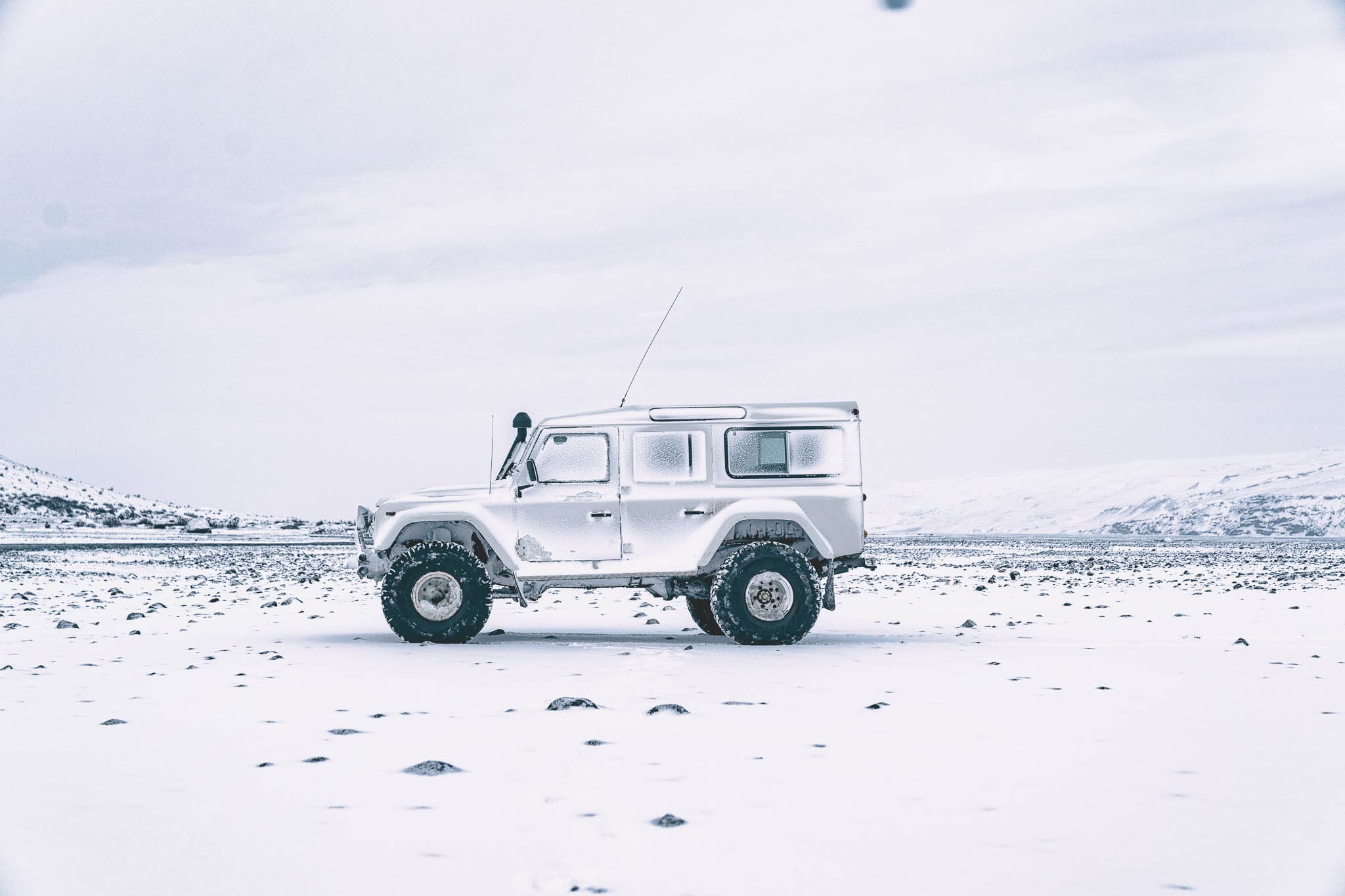 Kijkvoer: witte classic Defenders op IJslandse sneeuw