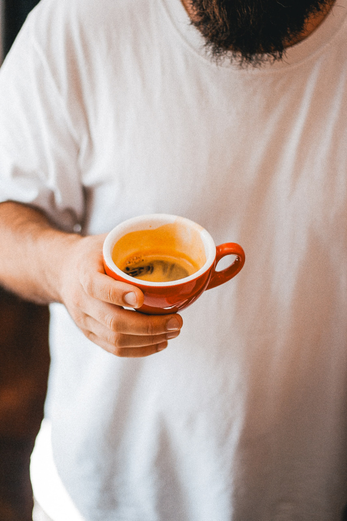 Man met koffiekopje vast